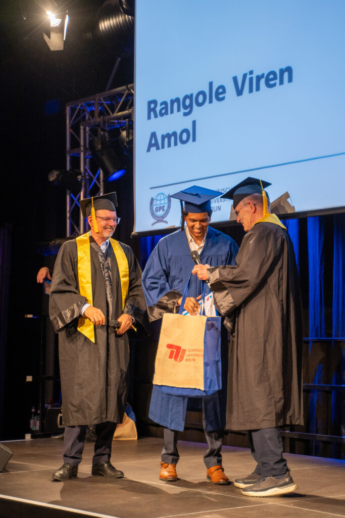 International graduate receiving a Master's certificate on stage from TU Berlin faculty during the Global Production Engineering convocation